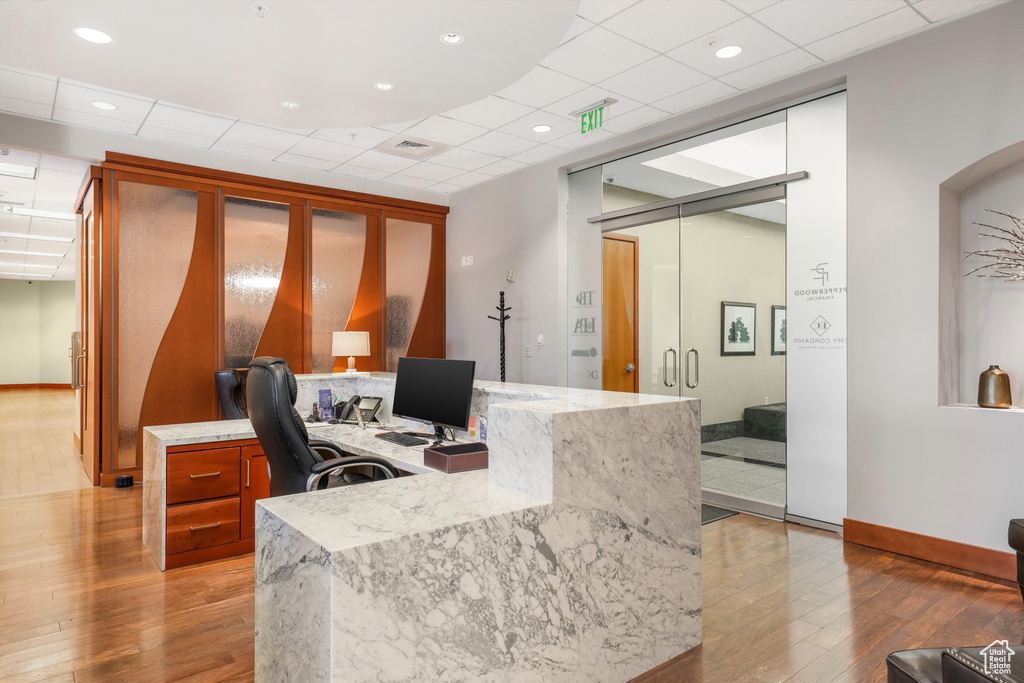 Office space featuring light wood-style flooring and a drop ceiling