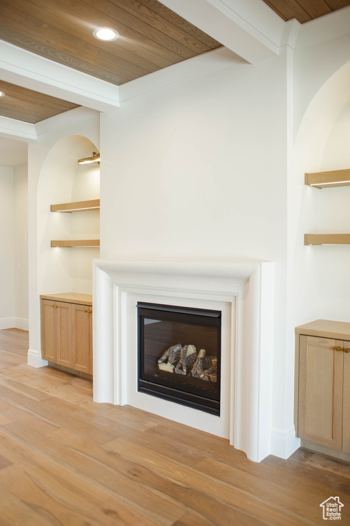Detailed view of wood finished floors, a glass covered fireplace, wood ceiling, and recessed lighting