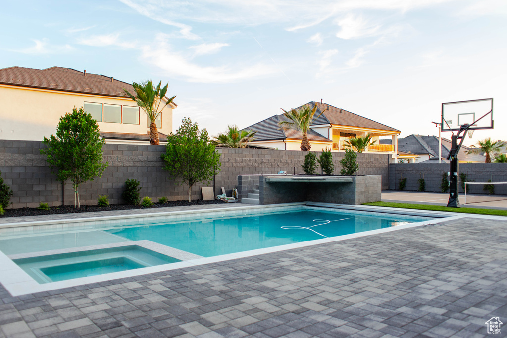 View of swimming pool with a fenced backyard, a patio, and a pool with connected hot tub