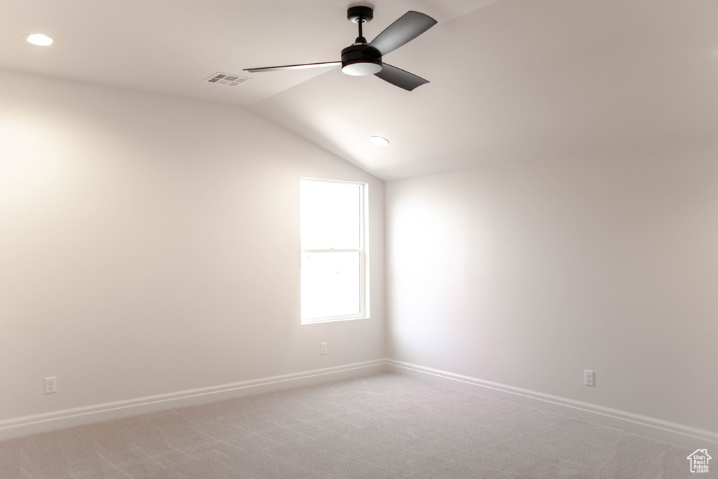 Spare room featuring a ceiling fan, vaulted ceiling, recessed lighting, and light carpet