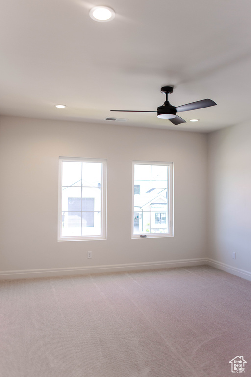 Spare room featuring light carpet, ceiling fan, and recessed lighting