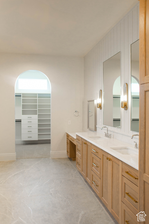 Full bathroom featuring double vanity and baseboards