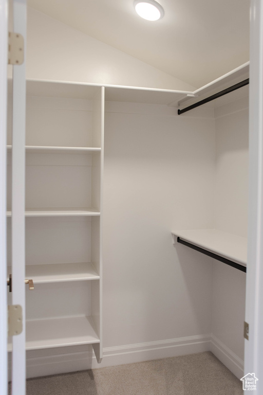 Walk in closet featuring carpet floors and vaulted ceiling