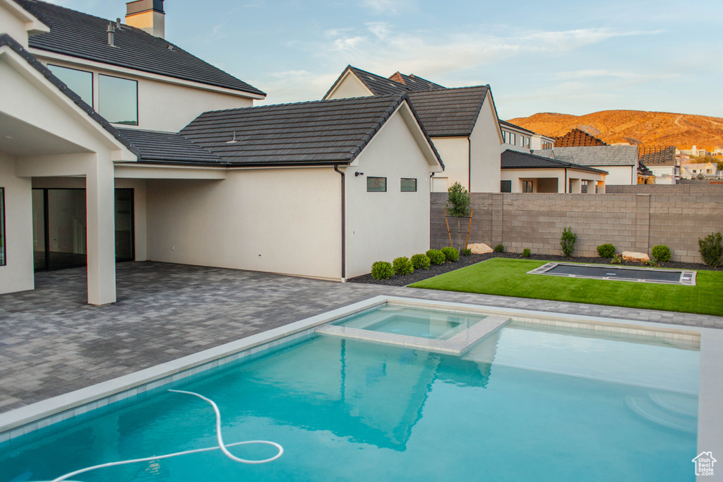 View of pool with a mountain view, a patio, and a pool with connected hot tub