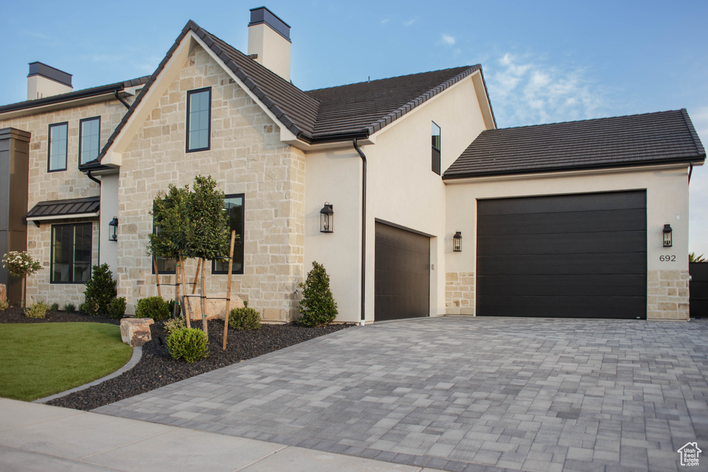 View of front of home featuring a chimney and stone siding