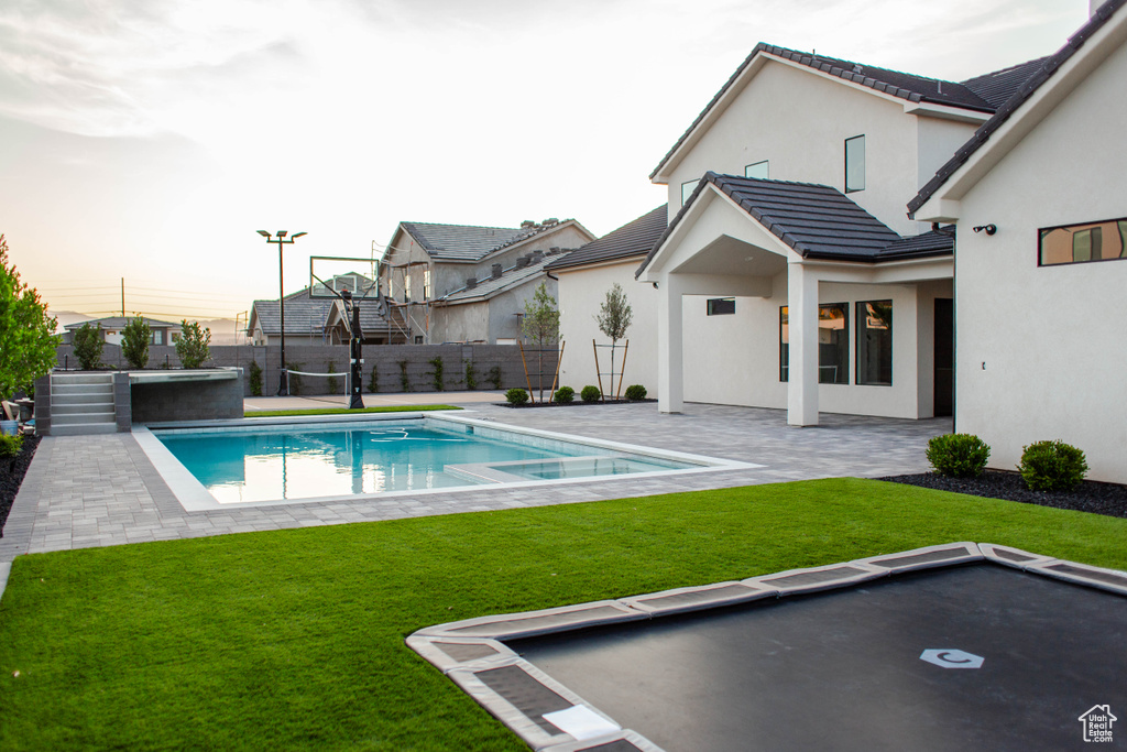 View of swimming pool with a patio area, a fenced backyard, and a pool with connected hot tub