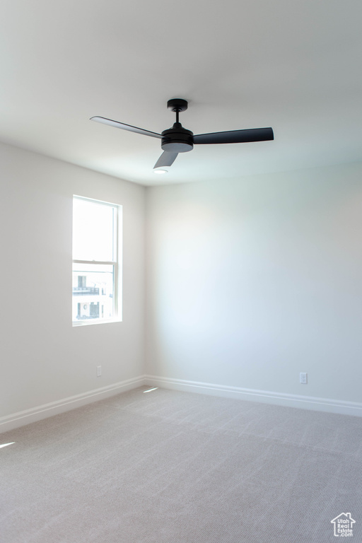 Unfurnished room with a ceiling fan and light colored carpet