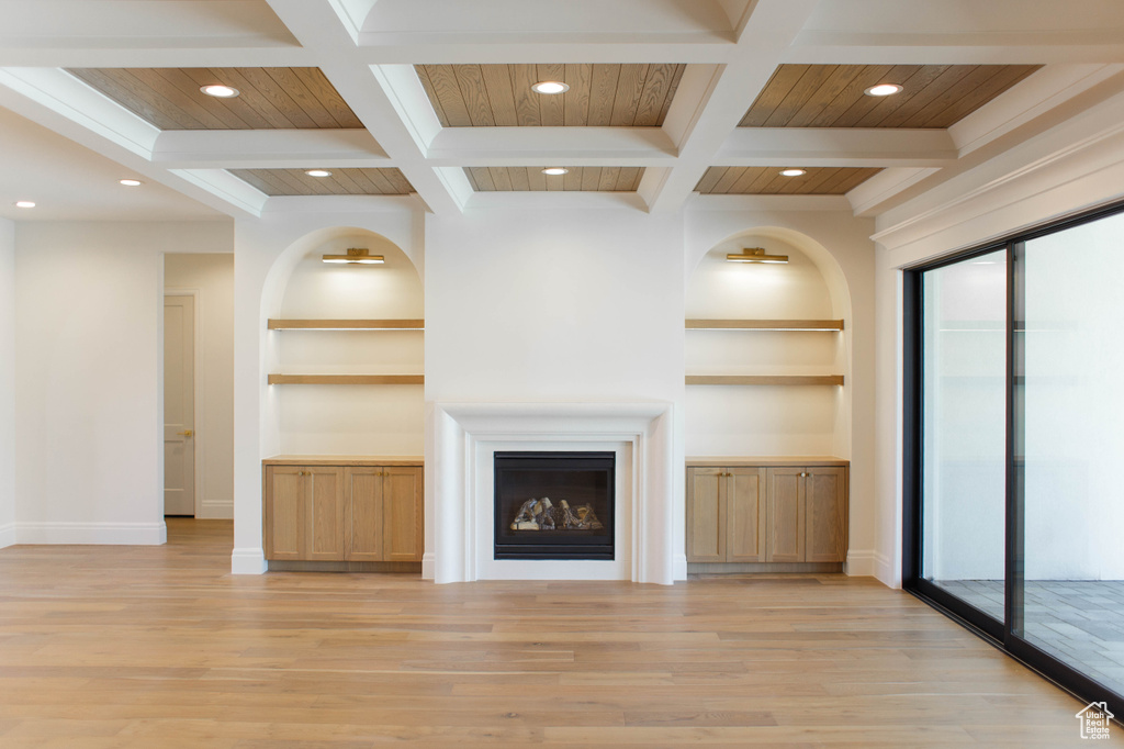 Unfurnished living room featuring built in features, light wood-style floors, recessed lighting, beamed ceiling, and a fireplace