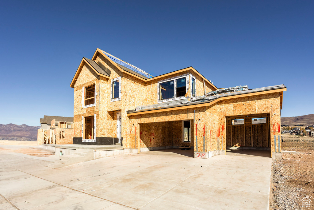 Property in mid-construction with a mountain view, driveway, and an attached garage