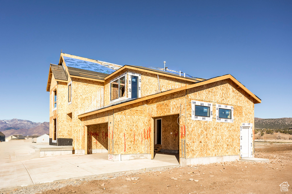 Rear view of house featuring a mountain view and an attached garage