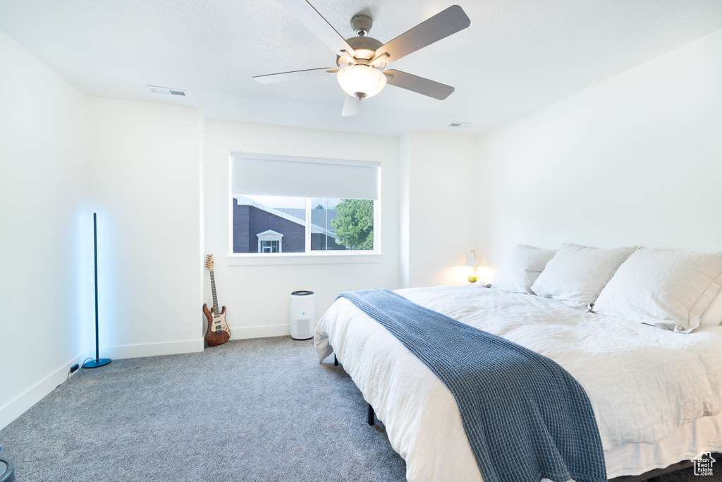Carpeted bedroom featuring baseboards and a ceiling fan
