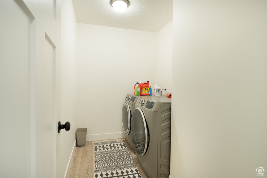 Laundry room featuring separate washer and dryer and wood finished floors