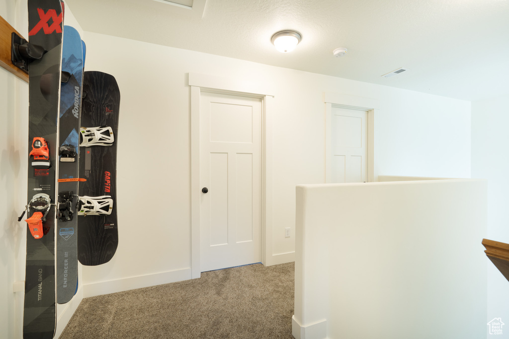 Hallway featuring carpet floors and baseboards