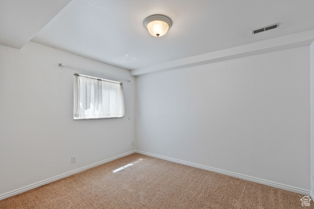Empty room featuring carpet flooring and baseboards