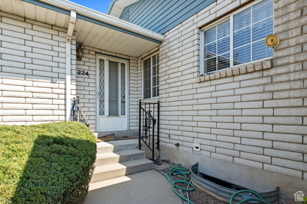 Entrance to property featuring brick siding