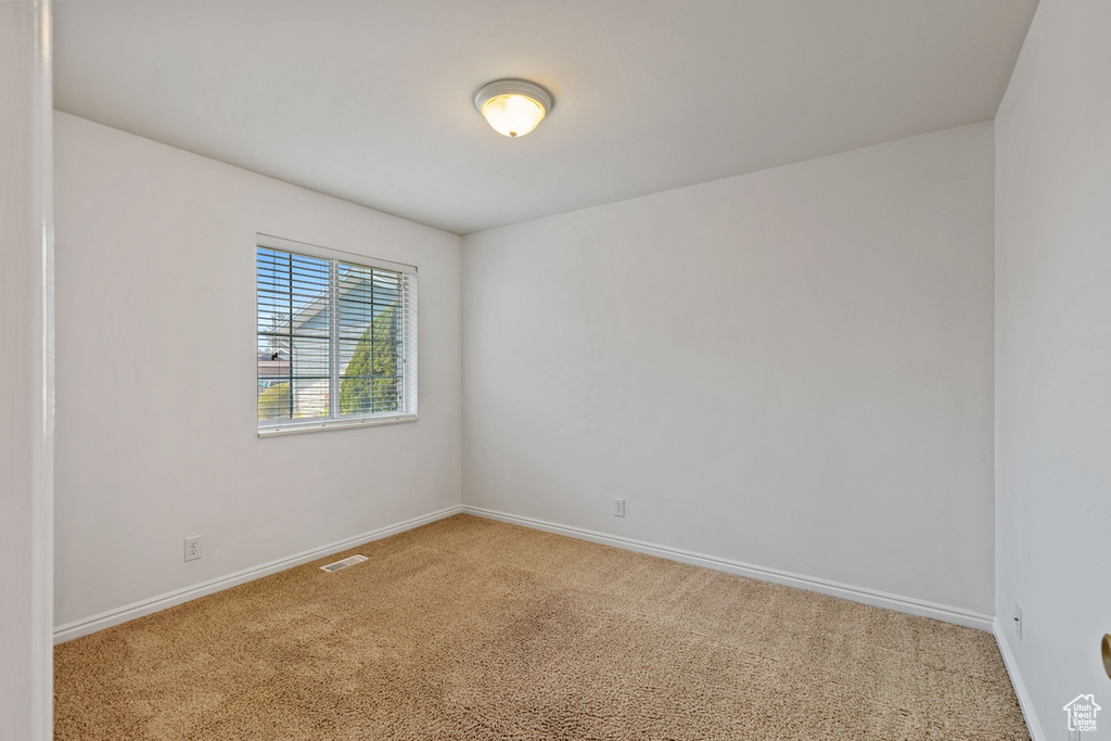 Empty room with carpet floors and baseboards