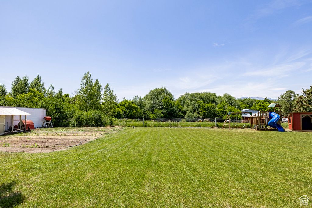 View of yard featuring a playground and an outdoor structure