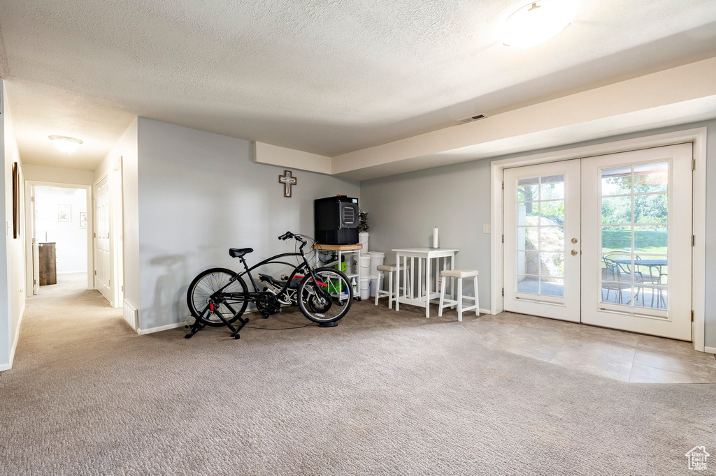 Game room with french doors, carpet floors, and a textured ceiling