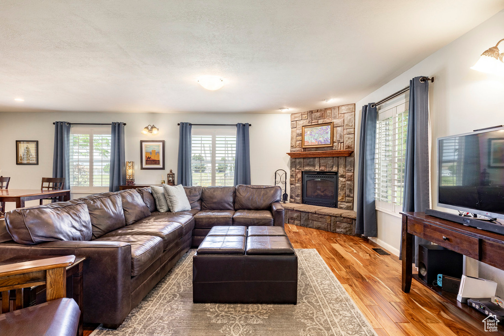 Living room with wood finished floors, healthy amount of natural light, a fireplace, and recessed lighting