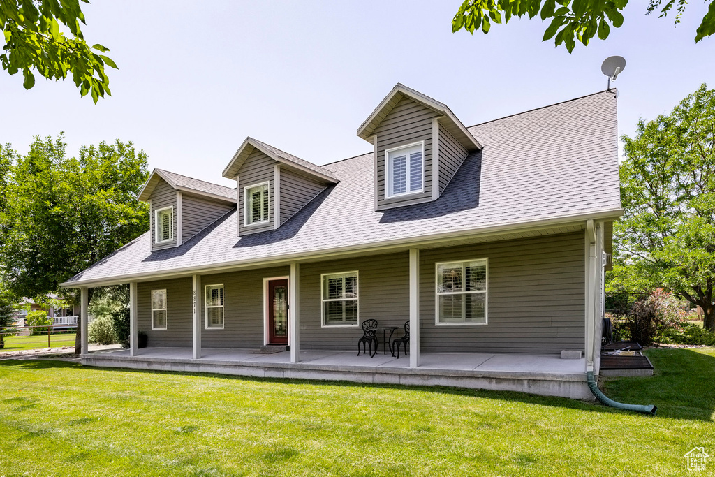 View of front of house featuring covered porch, a shingled roof, and a front lawn