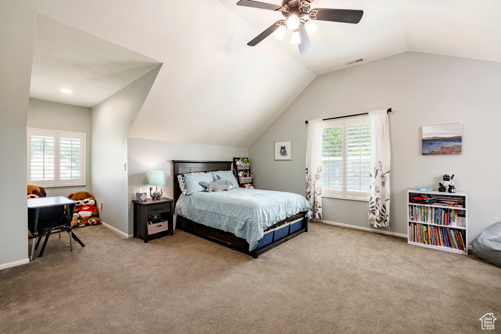 Carpeted bedroom featuring lofted ceiling, multiple windows, and a ceiling fan