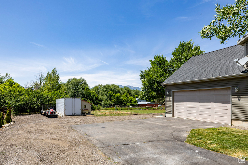 Garage with driveway and a shed