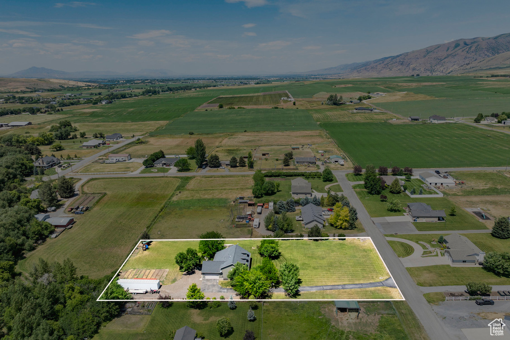 Aerial view of sparsely populated area featuring property parcel outlined and a mountainous background