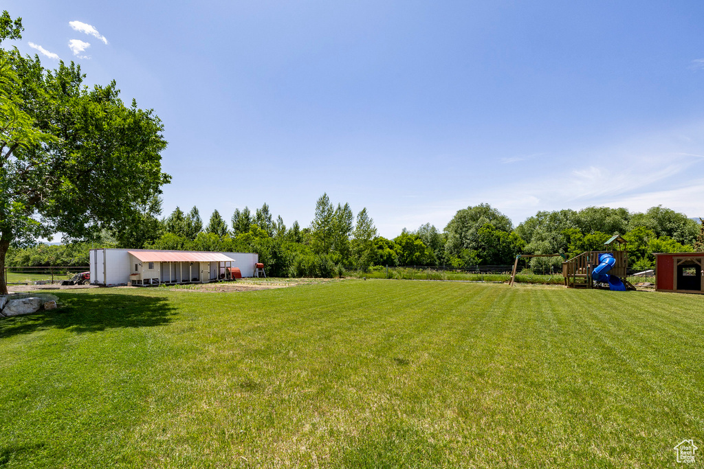View of yard with a playground and an outbuilding