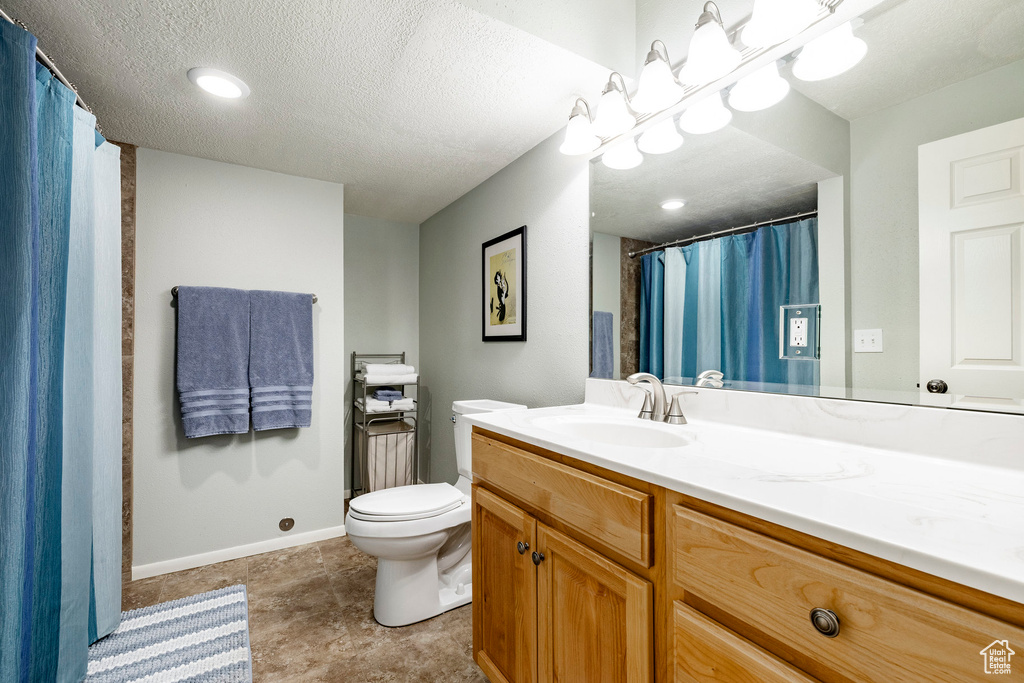 Full bathroom with vanity and a textured ceiling