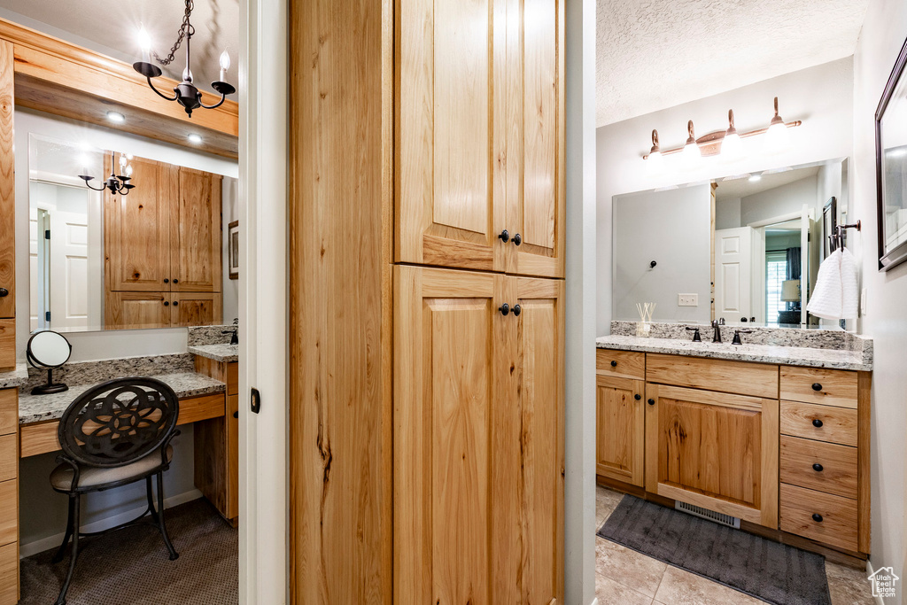 Bathroom featuring vanity, a chandelier, and tile patterned floors