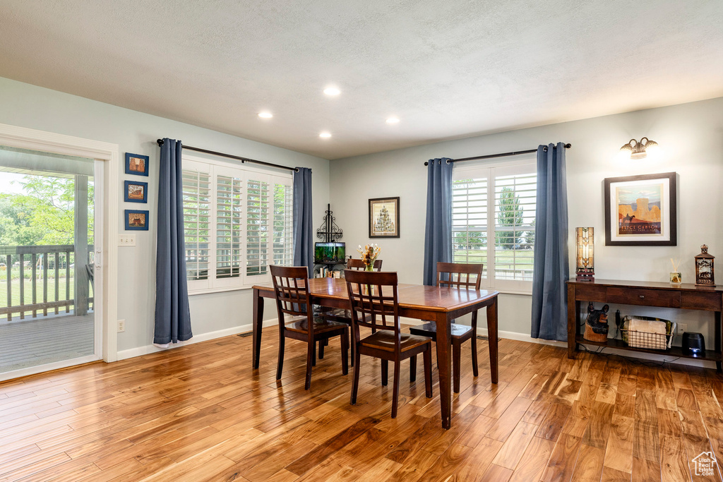 Dining room featuring light wood finished floors, recessed lighting, and healthy amount of natural light