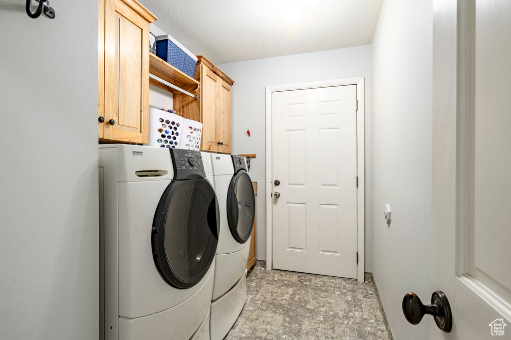 Laundry room featuring separate washer and dryer and cabinet space