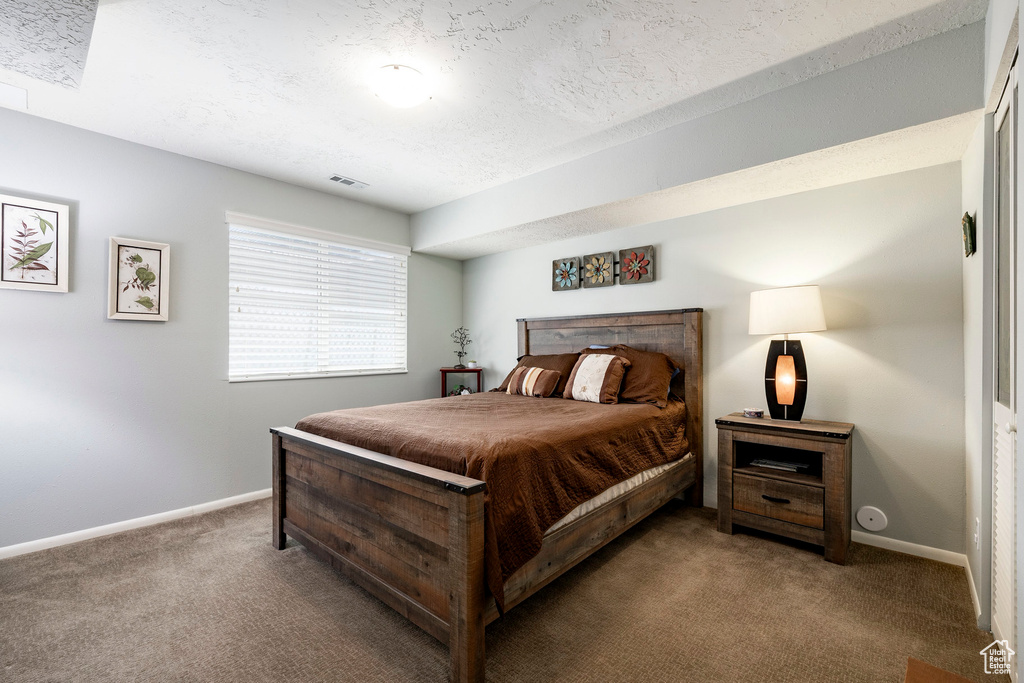 Bedroom featuring carpet flooring and a textured ceiling