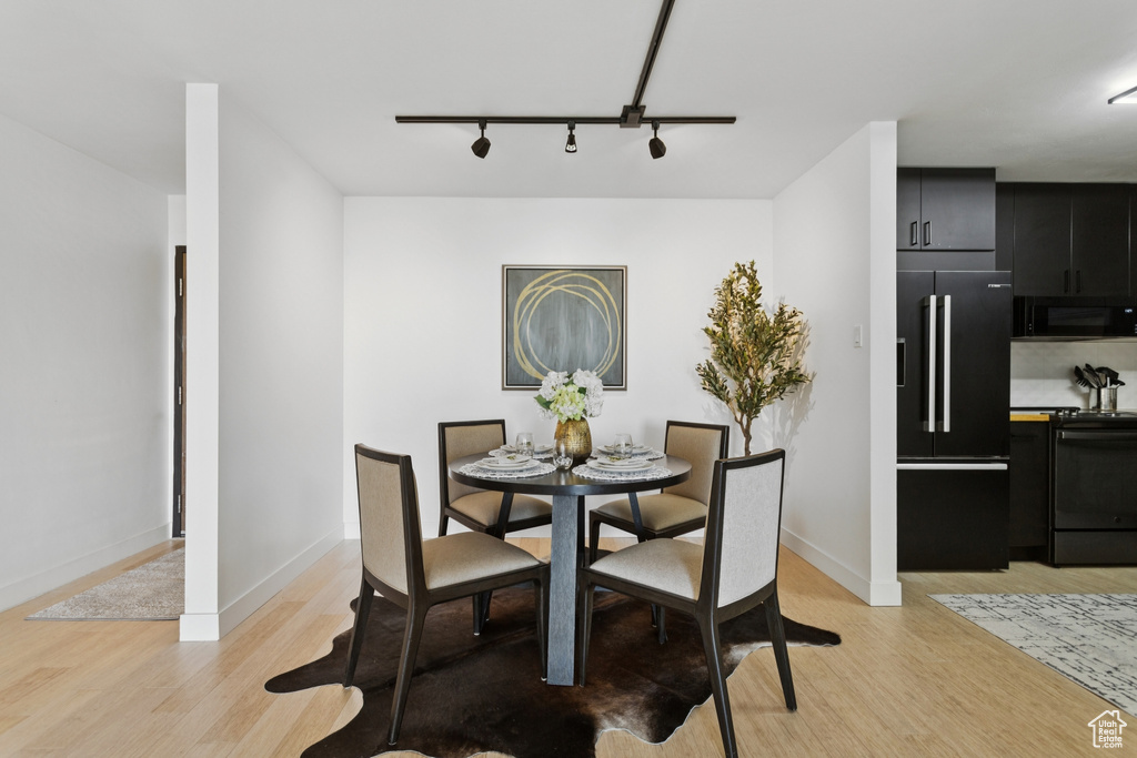 Dining room with light wood finished floors and track lighting