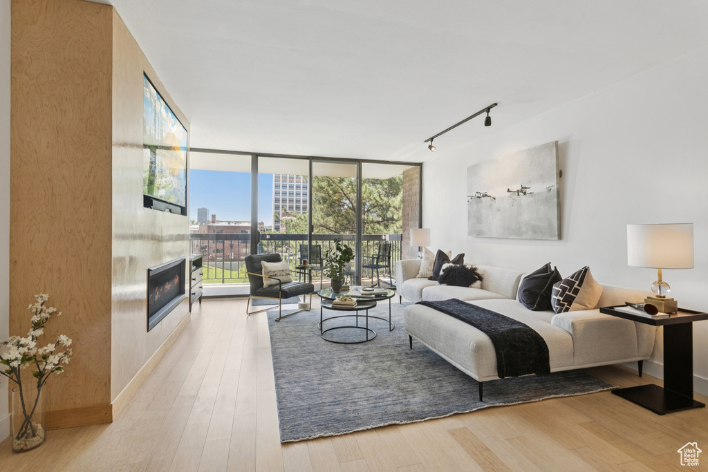 Bedroom with a large fireplace, floor to ceiling windows, rail lighting, access to exterior, and multiple windows