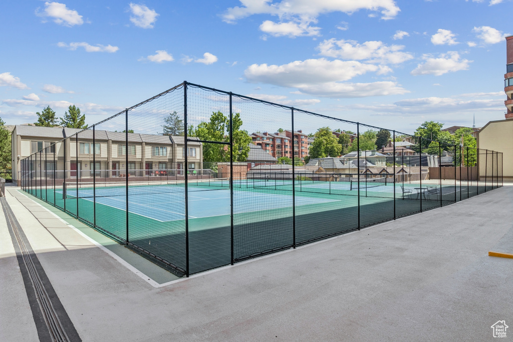 View of tennis court with a residential view