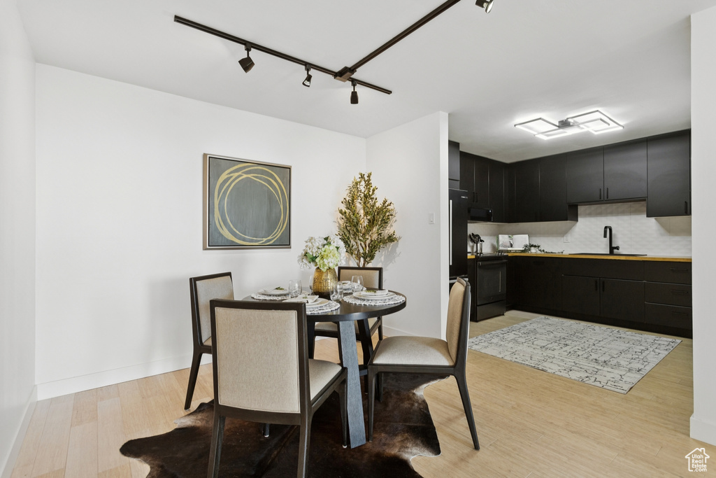 Dining space featuring light wood-style flooring and track lighting