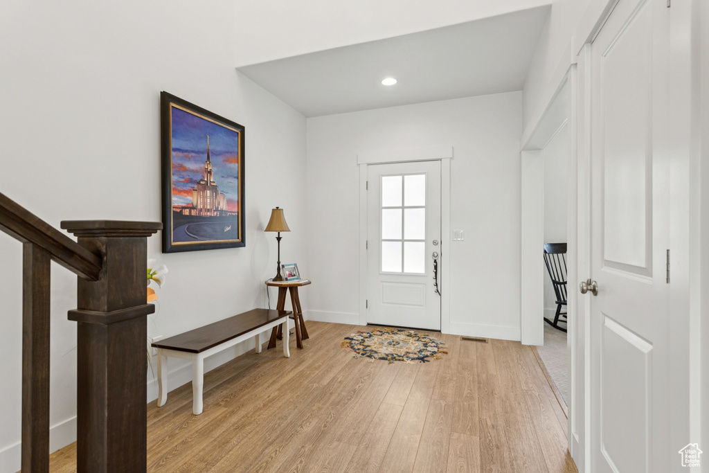 Entrance foyer with light wood-style floors and recessed lighting