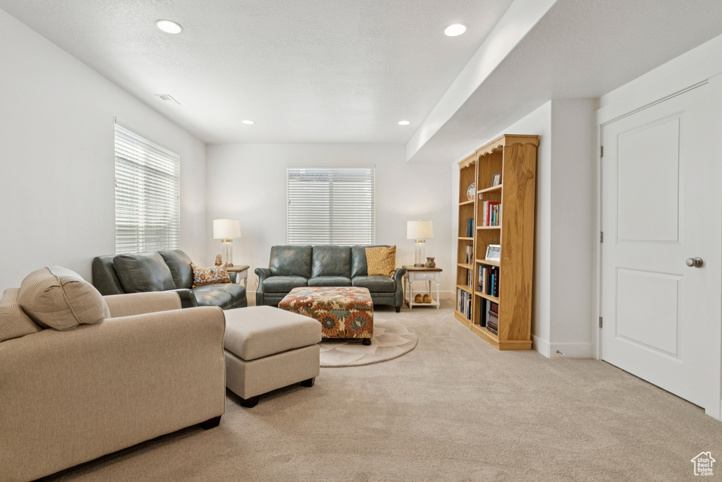 Carpeted living area featuring recessed lighting and baseboards