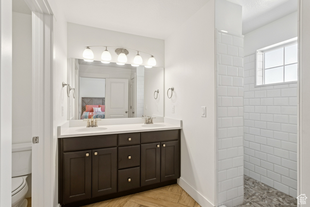 Full bath with double vanity, a walk in shower, and ensuite bathroom