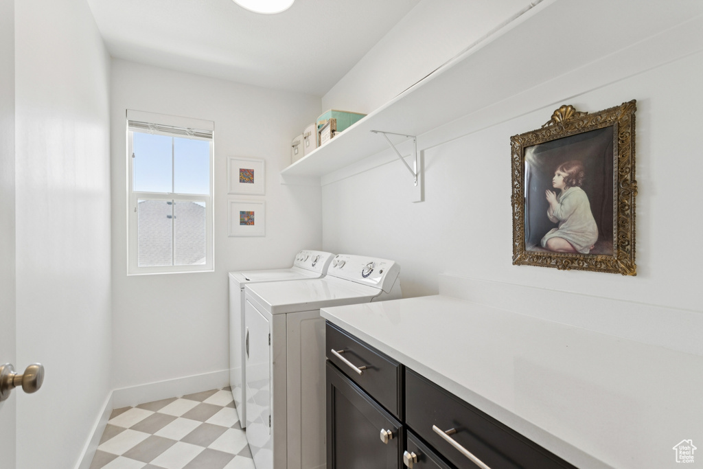 Laundry area featuring washer and dryer, cabinet space, and light flooring