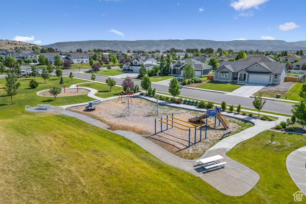 Aerial perspective of suburban area featuring a mountainous background and a recreational park