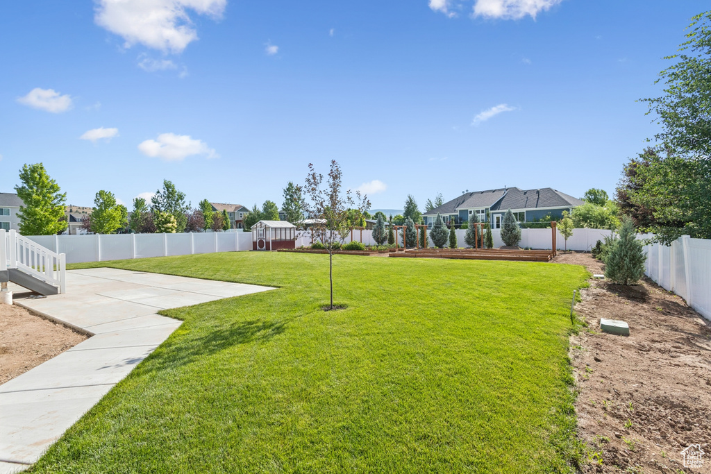 Fenced backyard with a patio area and a residential view