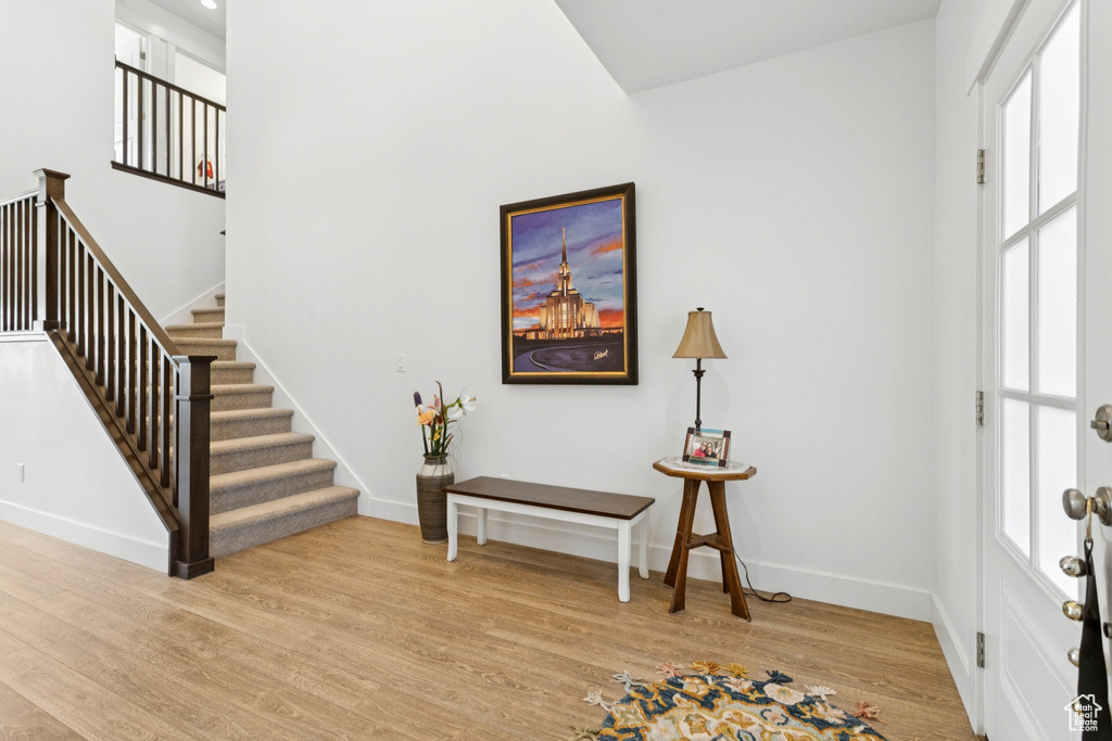 Entryway with light wood-style flooring, stairway, and plenty of natural light