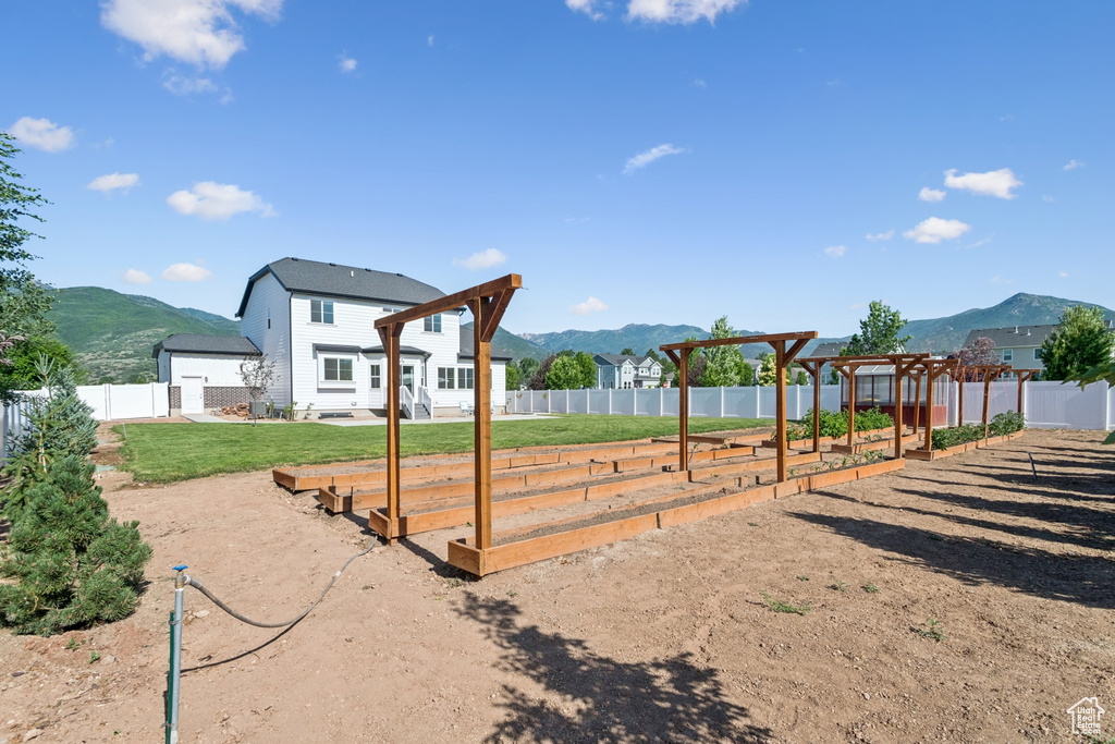 Fenced backyard featuring a mountain view and a pergola