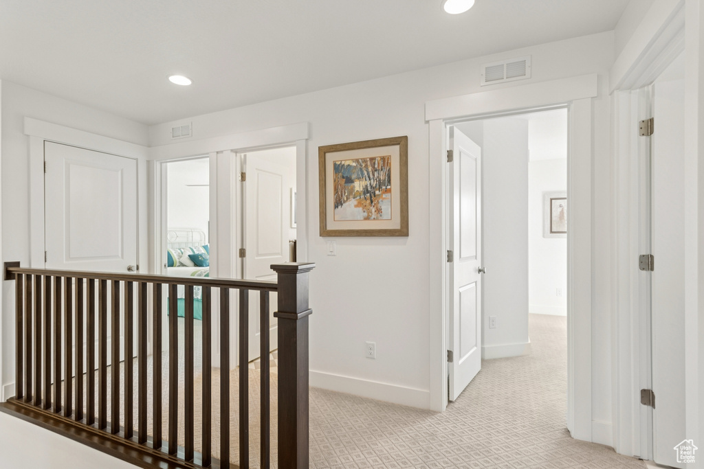 Hallway with recessed lighting and light colored carpet