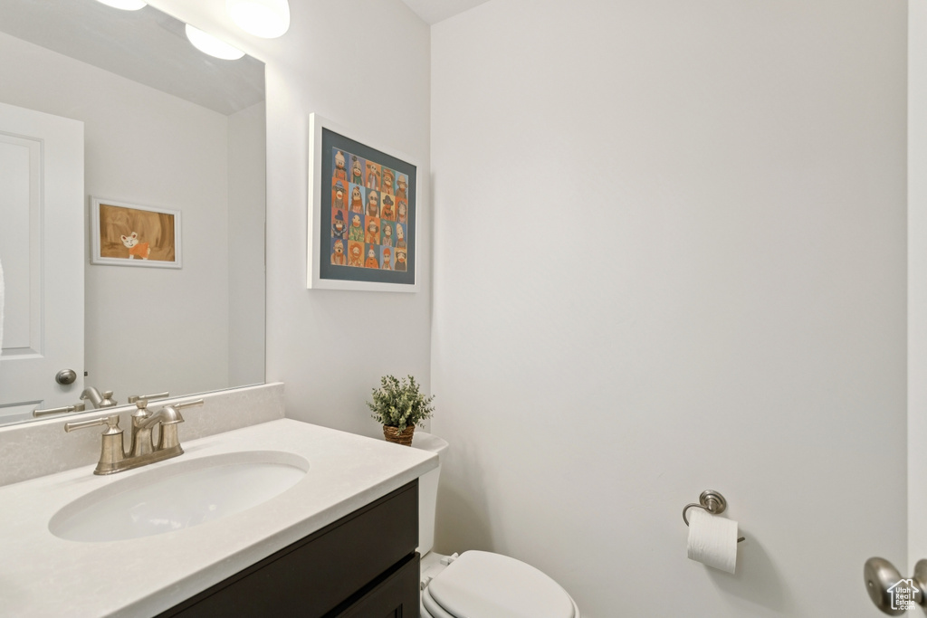 Half bathroom featuring vanity and toilet