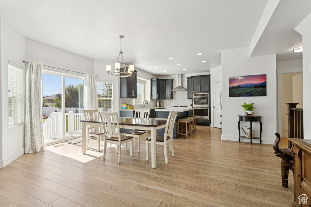 Dining room featuring a chandelier, light wood-style floors, and recessed lighting