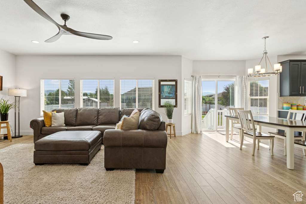 Living area with a ceiling fan, light wood-style flooring, a chandelier, and recessed lighting