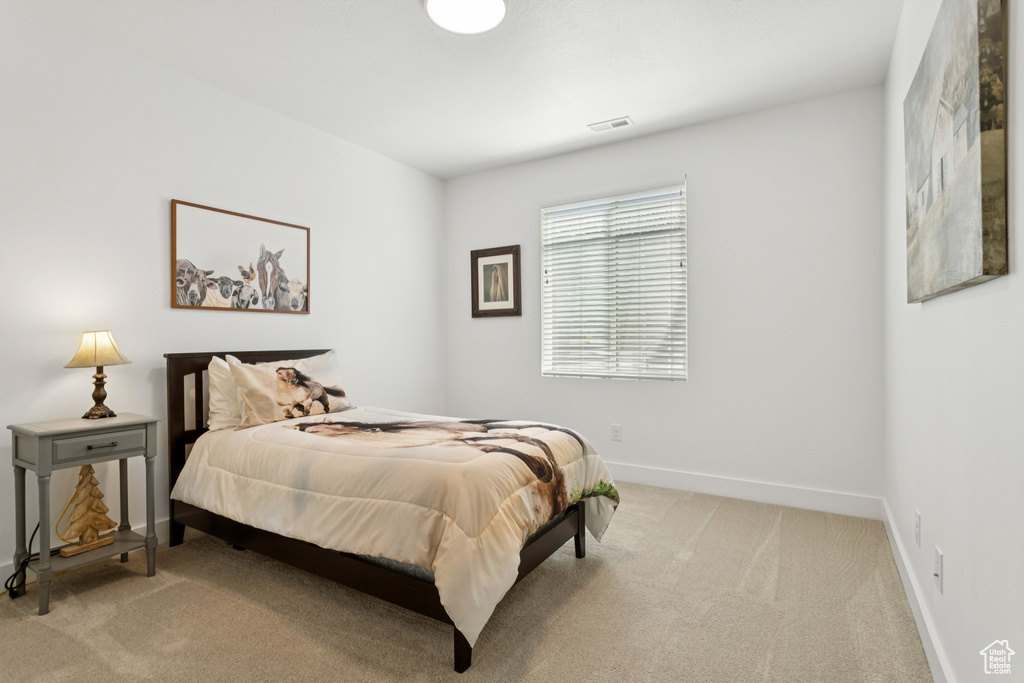 Bedroom featuring light colored carpet and baseboards
